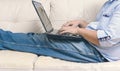 Close up of man working with laptop computer and sitting on sofa Royalty Free Stock Photo