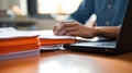 Close-up of a man working with a stack of documents and reports on his office desk. AI generated