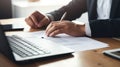 Close-up of a man working with a stack of documents and reports on his office desk. AI generated