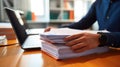 Close-up of a man working with a stack of documents and reports on his office desk. AI generated