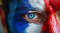 Close-up of a man's face painted with blue and red paint. Close look of a fan at Olympic sports competitions in Royalty Free Stock Photo