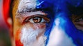 Close-up of a man's face painted with blue and red paint. Close look of a fan at Olympic sports competitions in Royalty Free Stock Photo