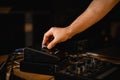 Close-up of a man& x27;s hand carefully turning a knob on an audio interface