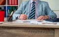 close-up of a man& x27;s hand checking accounting figures on a chart at an office desk.