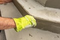 Close-up of a man& x27;s hand in work gloves leveling the surface of a step before laying paving. The man wipes the masonry