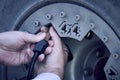 Close up man hands checking car tyre pressure measurement.