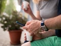 Close-up of a man& x27;s hands with a smartphone. Coffee break in the outdoors. Royalty Free Stock Photo