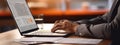Close-up of a man& x27;s hands typing on a laptop keyboard, with a stack of paperwork beside them. AI generated Royalty Free Stock Photo