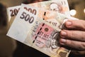 Close-up on a mans hand holding Czech koruna