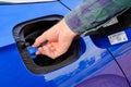 Close up mans hand opening a tank for Ad Blue fluid of a blue car. Diesel exhaust fluid or DEF for reduction of air Royalty Free Stock Photo