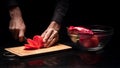 Close up of mans hands chopping tomato on black background Royalty Free Stock Photo