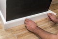 Close up of mans hands fitting skirting board Royalty Free Stock Photo