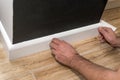 Close up of mans hands fitting skirting board