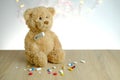 Close-up of many colored pills, medicine, capsules, teddy bear kids toy with stick thermometer, concept of pediatrics, childhood