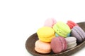 Close up many colorful fresh macarons pile isolated in wood ladle on white background, look delicious