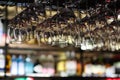 Many drinking glasses hanging upside down in bar rack at dark night Royalty Free Stock Photo