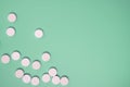Close up of many white pills on green background Royalty Free Stock Photo