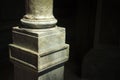 Close-up of a marble square column and a ray of sunshine in a dark room, selective focus