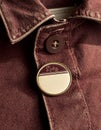 Close Up of Maroon Denim Jacket with Button and Circular Pin Royalty Free Stock Photo