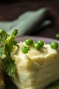 Close-up mashed potatoes and green peas on a white plate. Interesting serving in the restaurant