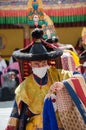 A close up of a Masked performer in traditional Ladakhi Costume