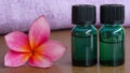 Close up of massage oil and pink frangipani flowers on a wooden table Royalty Free Stock Photo