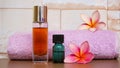 Close up of massage oil and pink frangipani flowers on a wooden table Royalty Free Stock Photo