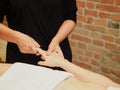 close-up masseuse doing hands relaxing massage to young caucasian woman in spa center wood cabin Royalty Free Stock Photo