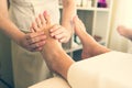 Close up of masseuse giving a foot reflexology treatment in a natural light tone in a spa salon, concept beauty and spa, pampering