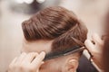 Close-up, master hairdresser does hairstyle with scissors comb. Concept Barbershop Royalty Free Stock Photo