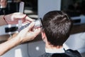 Close-up, master hairdresser does hairstyle and style with scissors and comb. Concept Barbershop Royalty Free Stock Photo
