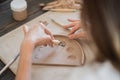 Close-up of a master potter, clay cutting special tool. Female artist cutting with a wooden loop tool