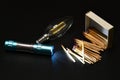 Close-up on matches, light bulb and burning flashlight on black background Royalty Free Stock Photo