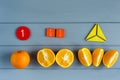 Close up mathematical fractions and oranges as a sample of parts on gray background. Creative, fun mathematics banner. Education