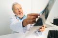 Close-up of mature adult male doctor explaining results of MRI scanning, pointing on image, giving professional Royalty Free Stock Photo