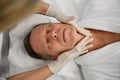 Close-up of a mature European man relaxing at wellness spa while receiving professional male beauty treatment, skin care, face Royalty Free Stock Photo