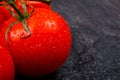 Ripe, appetizing bright tomatoes on a black background.