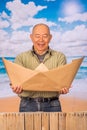 Close up of mature man with brown paper origami boat, concept for aspirations, leadership, strategy or just boredom in Royalty Free Stock Photo