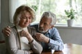 Close up mature man comforting frustrated crying wife, hugging