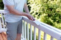 Close up of mature man scraping old paint from outdoor deck Royalty Free Stock Photo
