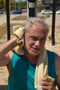 close-up of mature man wiping sweat after hard training on the street with sports machine Royalty Free Stock Photo