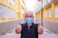 Close up of mature senior man happy because we win the covid-19 together - staysafe wearing mask and stay at home - smiling in the Royalty Free Stock Photo