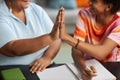 Close-up of mature tutor giving high five to teenage student