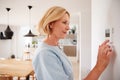 Close Up Of Mature Woman Adjusting Central Heating Temperature At Home On Thermostat Royalty Free Stock Photo