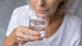 Close up mature woman holding glass of fresh pure water