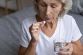 Close up mature woman holding pill and glass of water Royalty Free Stock Photo