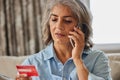 Close Up Of Mature Woman At Home Giving Credit Card Details On Mobile Phone Royalty Free Stock Photo