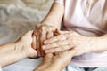 Close up of mature womans & nurse hands. Health care giving, nursing home. Parental love of grandmother. Old age related diseases.