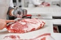 Close up of meat pieces and worker hands in gloves cutting. Royalty Free Stock Photo