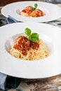 Close-Up meatballs in tomato sauce with spaghetti on white plates, cherry tomatoes on a wooden table Royalty Free Stock Photo